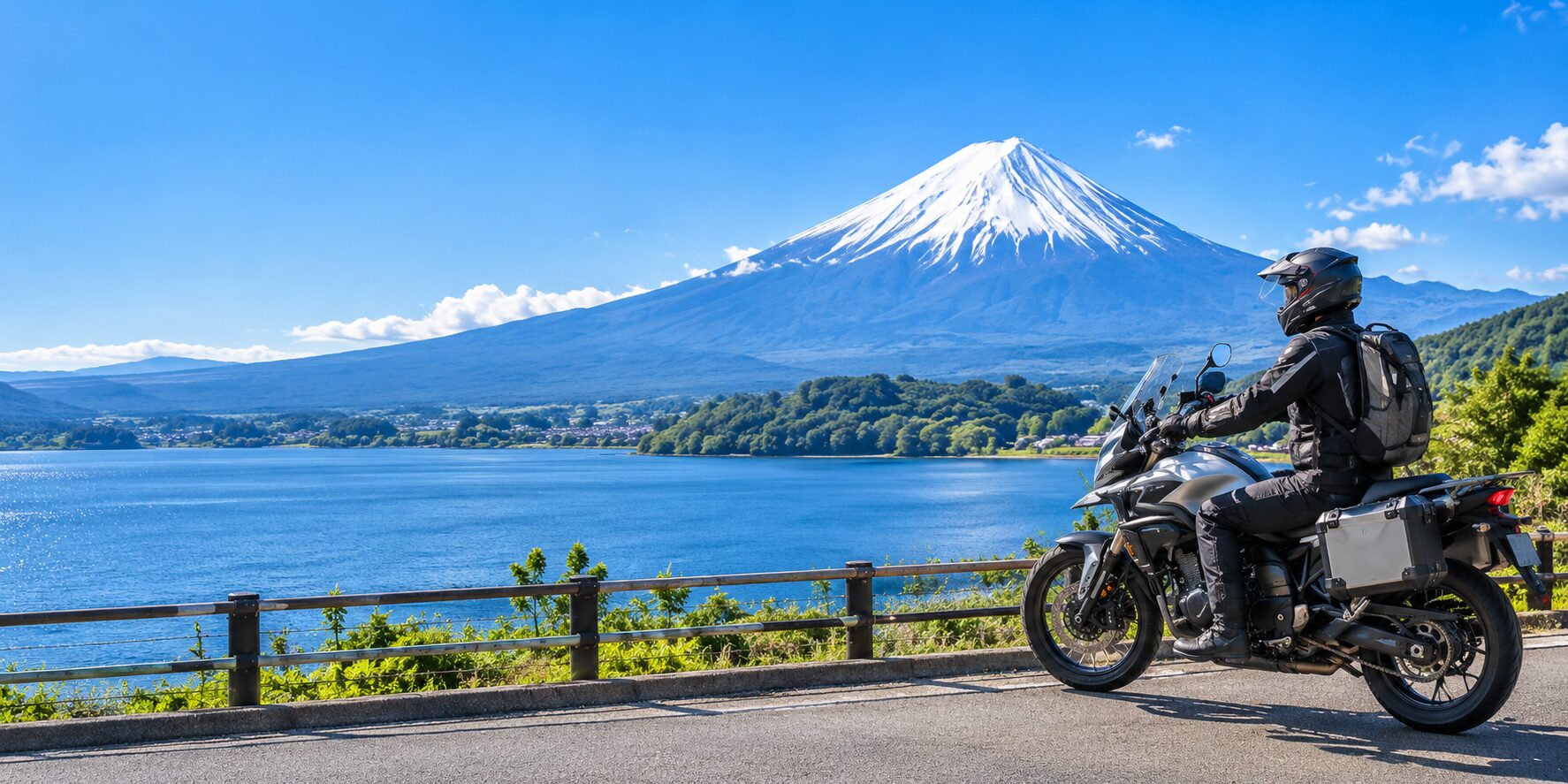 A rider on an adventure motorcycle looking at Mt. Fuji across a lake